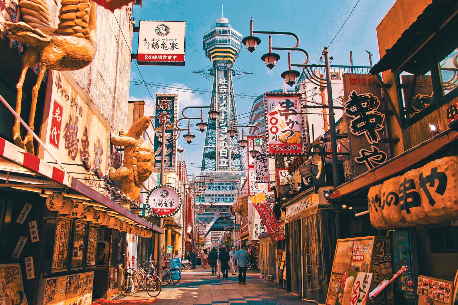Skyline d’Osaka avec des voies ferrées surélevées, des rues urbaines denses et des enseignes au néon au crépuscule